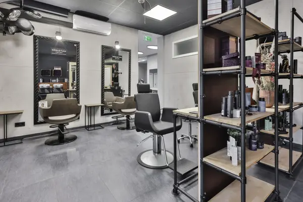 Moderner Friseursalon mit Stylingstühlen, Spiegeln und Haarpflegeprodukten