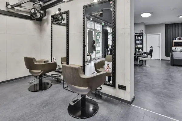 Moderner Friseursalon mit Stylingstühlen, großen Spiegeln und Waschecke.