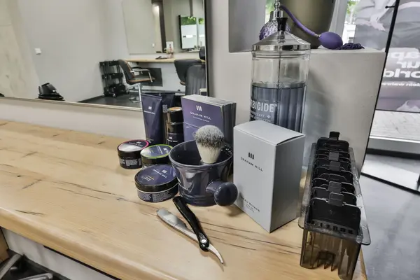 Barbershop-Arbeitsplatz mit Rasierpinsel, Pomade, Schere und Haarschneidemaschine