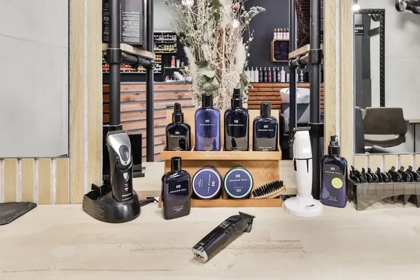 Barbershop-Spiegel mit Haarschneidemaschinen und Bartpflege-Produkten auf Tisch